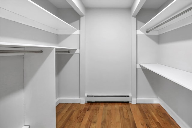 walk in closet with hardwood / wood-style flooring and baseboard heating