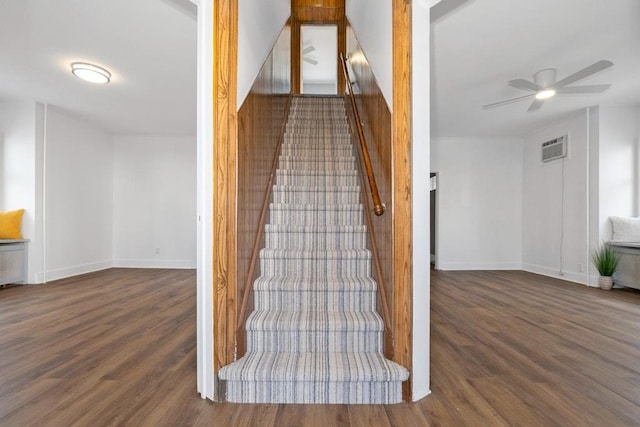 stairway featuring hardwood / wood-style flooring, a wall unit AC, and ceiling fan