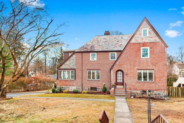 english style home with a front lawn