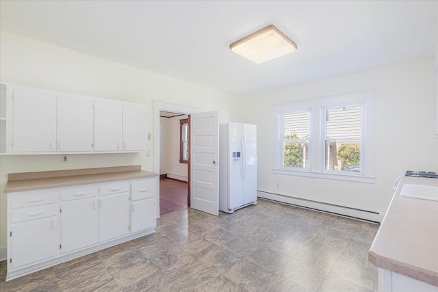 kitchen with white refrigerator with ice dispenser, a baseboard radiator, and white cabinetry