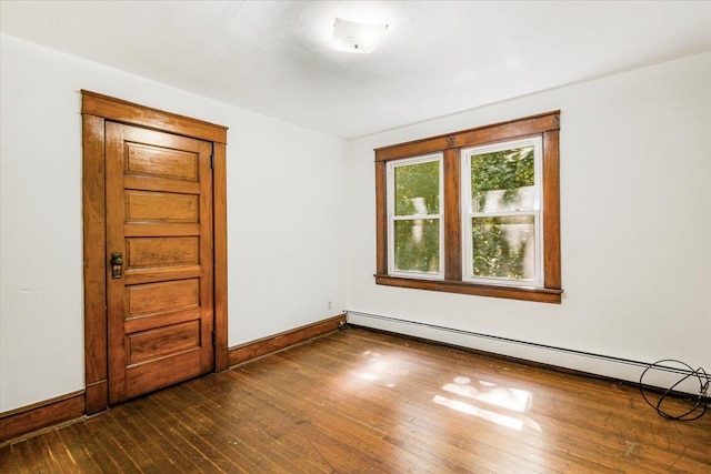 unfurnished room featuring dark hardwood / wood-style floors and a baseboard radiator