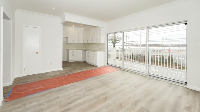 unfurnished living room with light hardwood / wood-style floors and ornamental molding