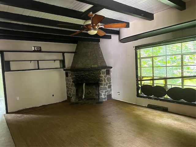 unfurnished living room with beam ceiling, ceiling fan, and a fireplace