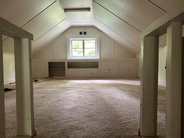 additional living space featuring light carpet and vaulted ceiling