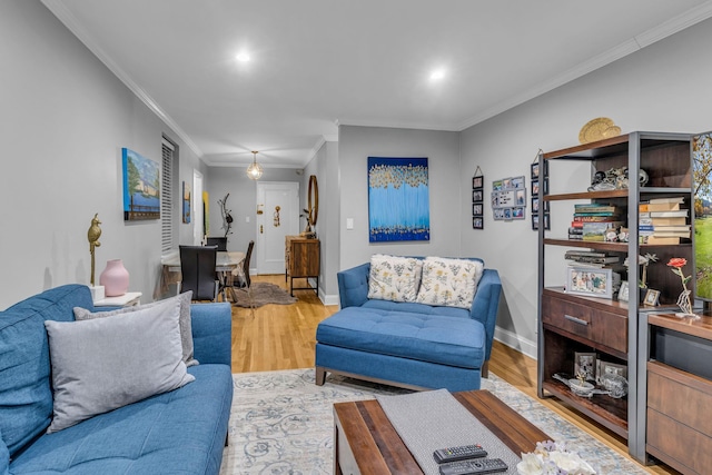 living room with light wood-type flooring and ornamental molding