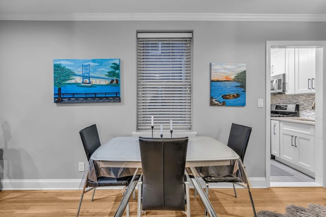 dining space featuring ornamental molding and light hardwood / wood-style floors