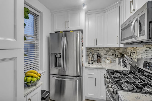 kitchen with white cabinets, decorative backsplash, light stone counters, and appliances with stainless steel finishes