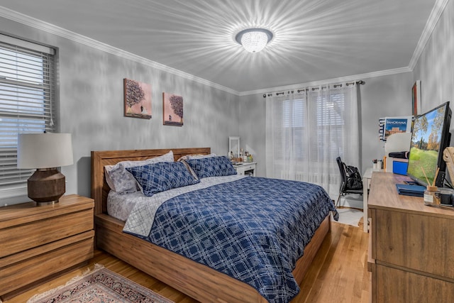 bedroom featuring ornamental molding and hardwood / wood-style floors