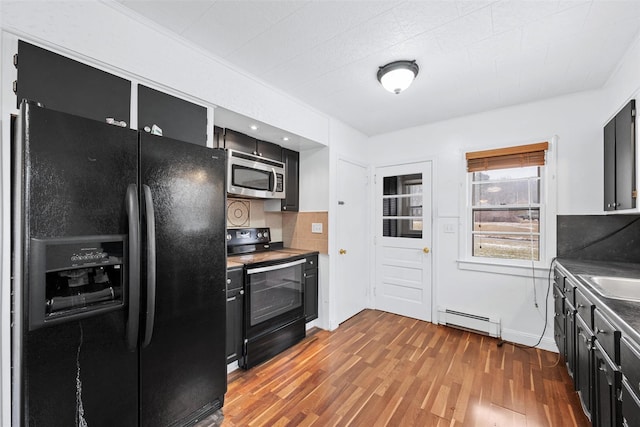 kitchen with wood-type flooring, sink, decorative backsplash, baseboard heating, and black appliances