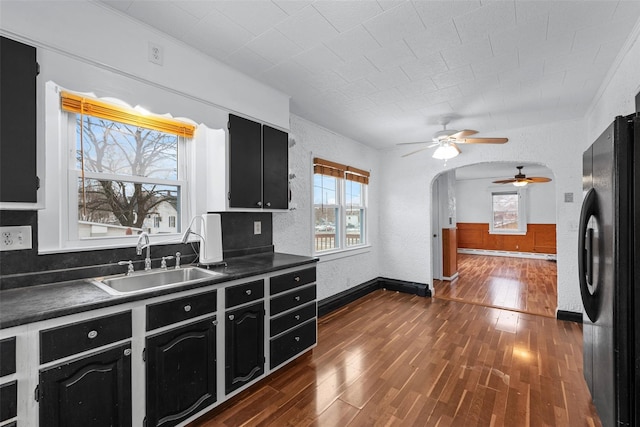 kitchen featuring sink, black refrigerator, a baseboard radiator, dark hardwood / wood-style floors, and ceiling fan