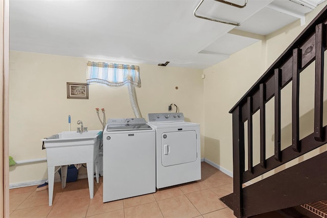 laundry area with light tile patterned floors and washing machine and clothes dryer