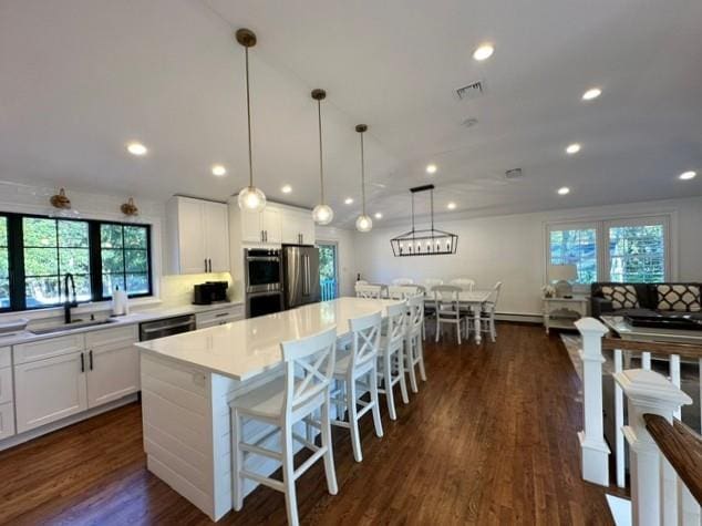 kitchen featuring white cabinets, a center island, and hanging light fixtures