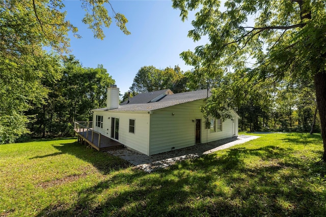 view of side of home featuring a lawn and a deck