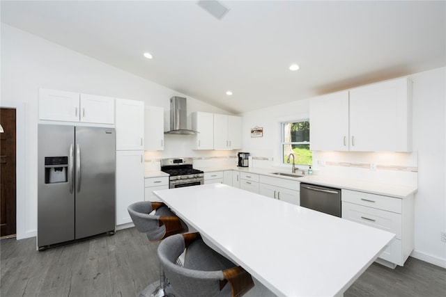 kitchen with white cabinets, wall chimney exhaust hood, sink, and appliances with stainless steel finishes