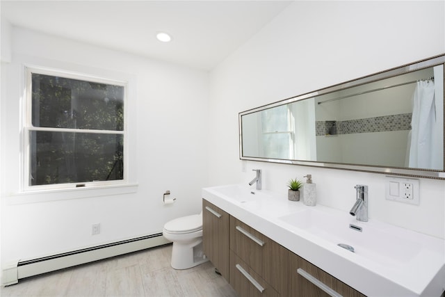 bathroom featuring vanity, toilet, walk in shower, and a baseboard heating unit