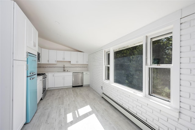 kitchen featuring lofted ceiling, a baseboard heating unit, white cabinets, sink, and stainless steel appliances