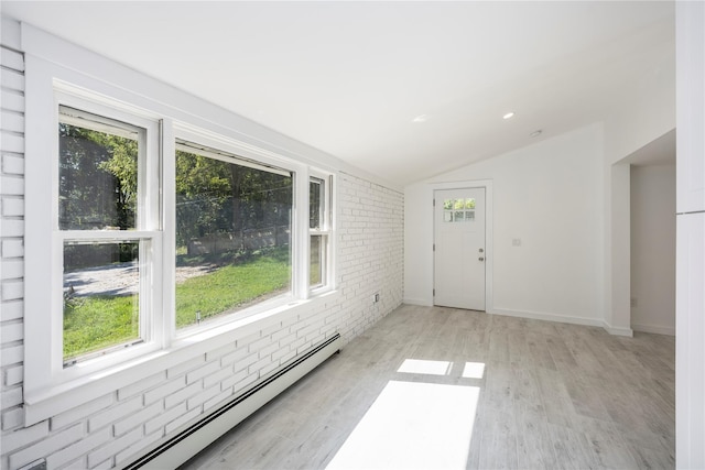 interior space with light wood-type flooring, brick wall, lofted ceiling, and a baseboard heating unit