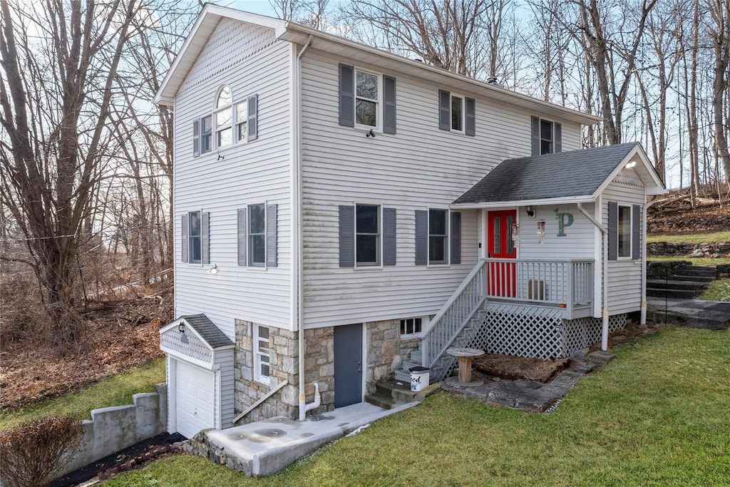 rear view of house with a garage and a lawn