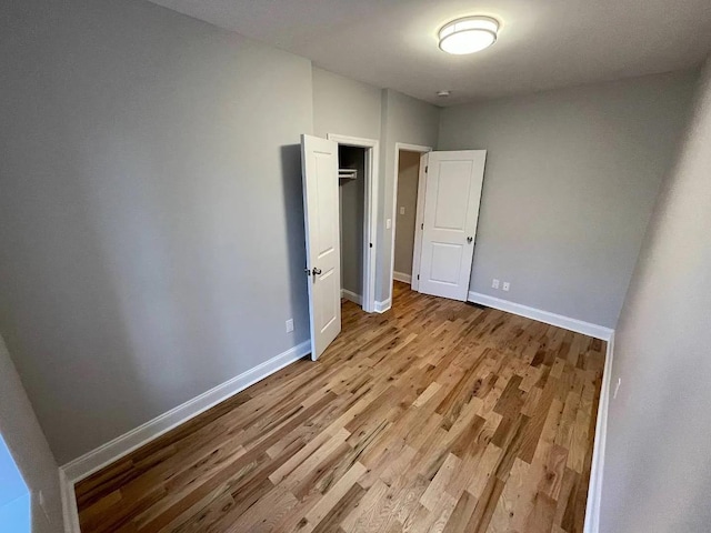 unfurnished bedroom with light hardwood / wood-style floors and a closet