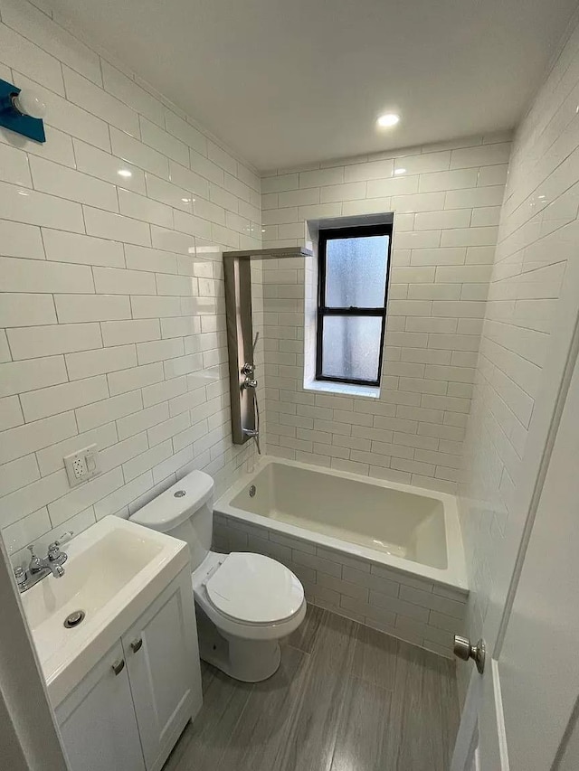 bathroom with hardwood / wood-style flooring, vanity, toilet, and tile walls