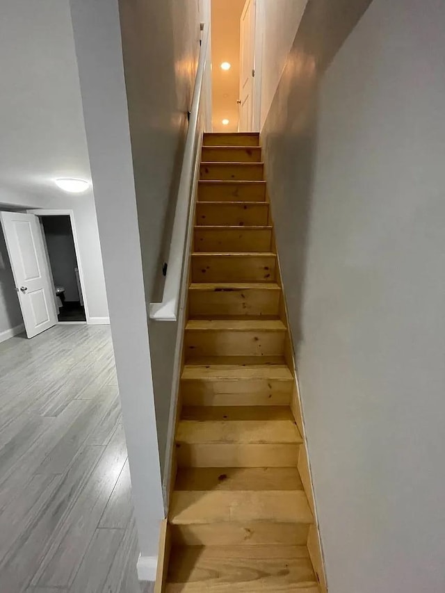 staircase with hardwood / wood-style flooring