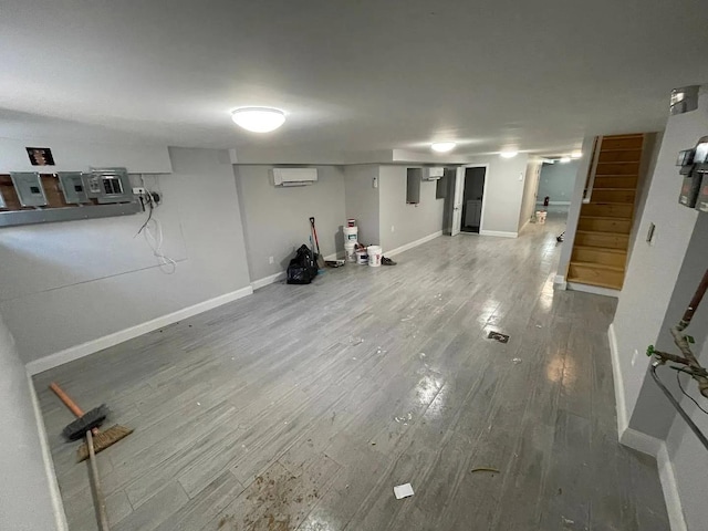 basement with hardwood / wood-style flooring and a wall unit AC