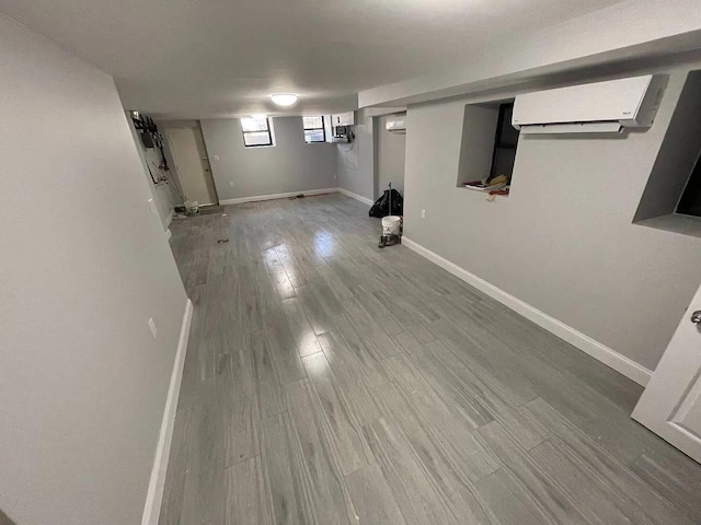 basement with a wall mounted AC and hardwood / wood-style floors