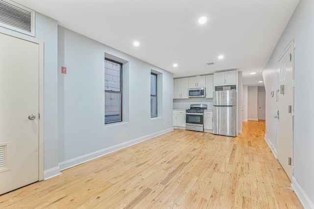 kitchen with white cabinetry, light hardwood / wood-style floors, and appliances with stainless steel finishes