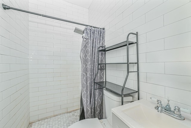 bathroom featuring a shower with shower curtain, toilet, sink, and tile walls