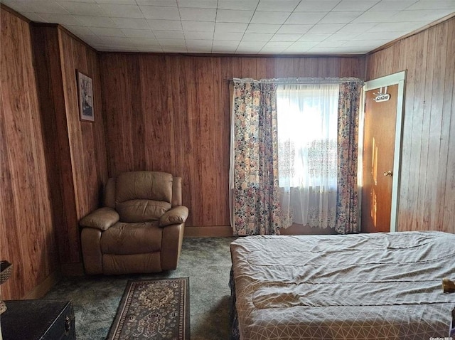 bedroom featuring carpet flooring and wood walls