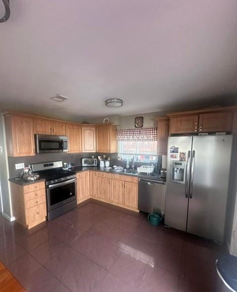 kitchen featuring sink, stainless steel appliances, and dark tile patterned floors