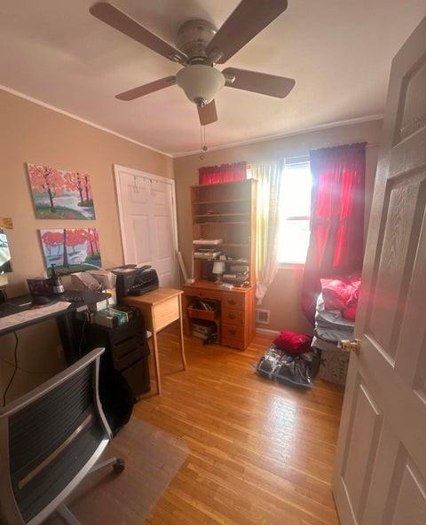 office featuring light wood finished floors, crown molding, visible vents, and a ceiling fan