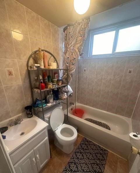 bathroom featuring tile walls, toilet, tub / shower combination, vanity, and tile patterned flooring