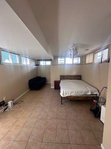 bedroom featuring light tile patterned floors and baseboards