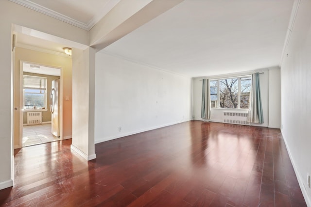 spare room with dark hardwood / wood-style floors, radiator heating unit, and crown molding