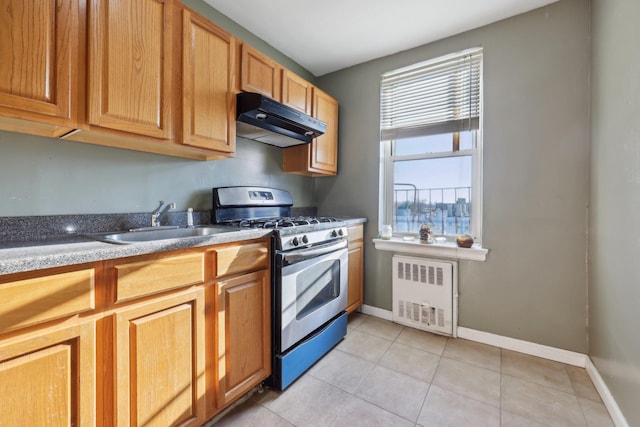 kitchen featuring light tile patterned floors, stainless steel range with gas cooktop, radiator, and sink