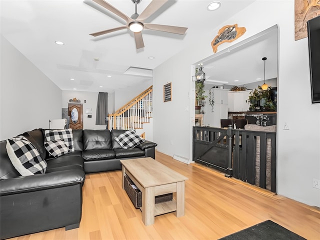 living room featuring wood-type flooring and ceiling fan