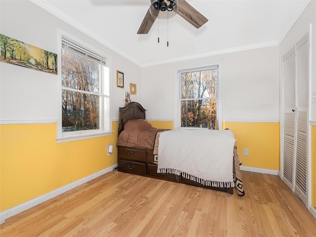 bedroom with multiple windows, hardwood / wood-style floors, ceiling fan, and crown molding