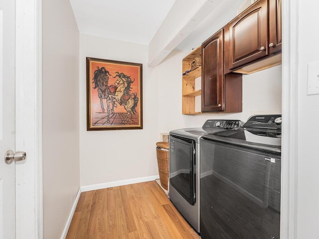 washroom with cabinets, separate washer and dryer, and light hardwood / wood-style floors