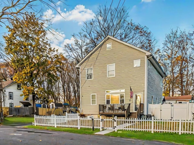 rear view of house featuring a wooden deck