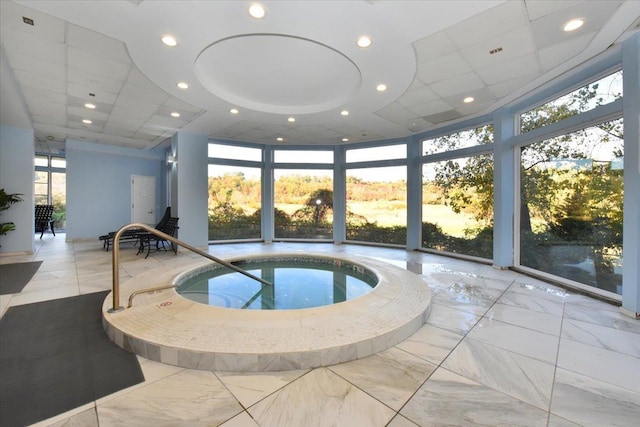 pool at dusk with an indoor in ground hot tub