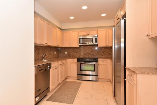 kitchen with stainless steel appliances, sink, light tile patterned floors, and backsplash