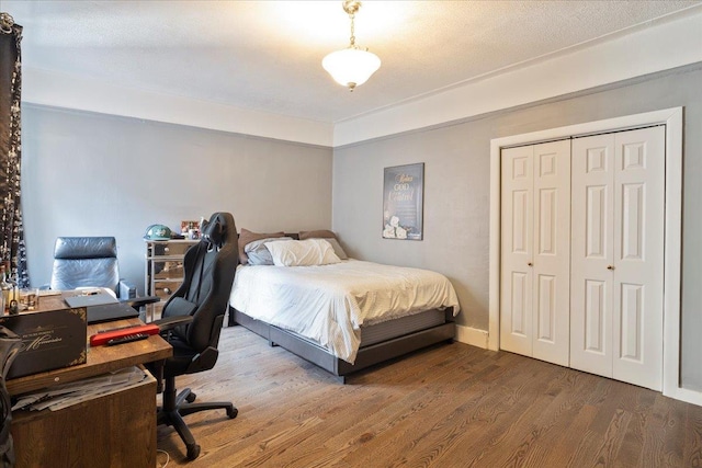 bedroom with dark wood-type flooring and a closet