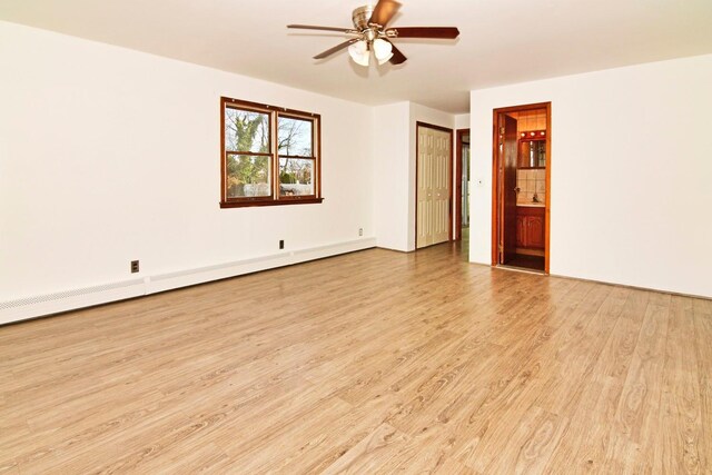 empty room featuring light wood-type flooring, a baseboard radiator, and ceiling fan