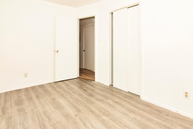 unfurnished bedroom featuring light hardwood / wood-style floors and a closet