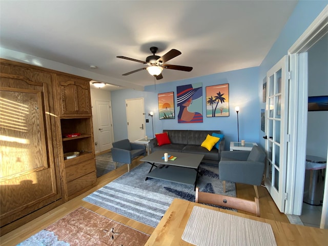 living room featuring ceiling fan, french doors, and light wood-type flooring