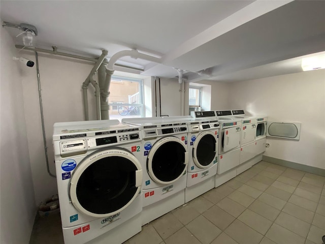 washroom with separate washer and dryer and light tile patterned flooring