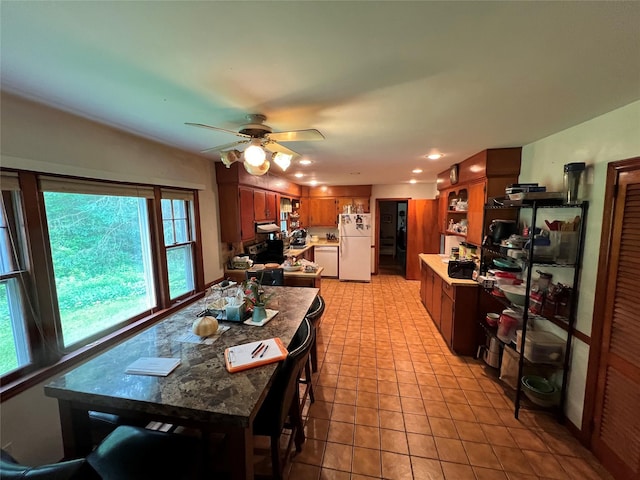 tiled dining area with ceiling fan