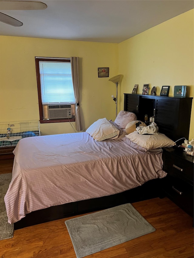 bedroom featuring ceiling fan, cooling unit, wood-type flooring, and radiator