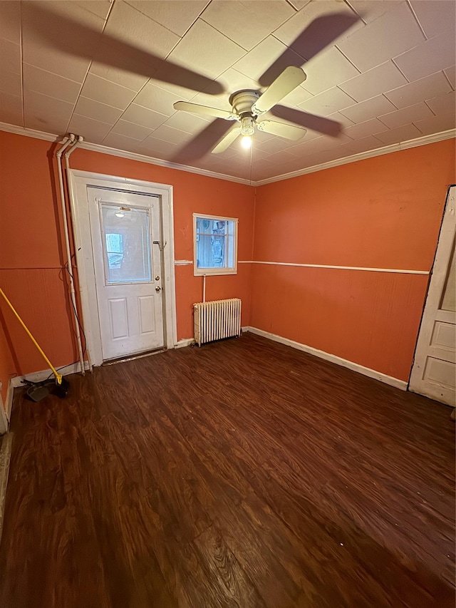 foyer with radiator heating unit, ornamental molding, and hardwood / wood-style flooring